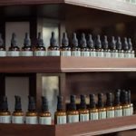 A rustic wooden shelf displaying brown bottles with labels in an apothecary setting.